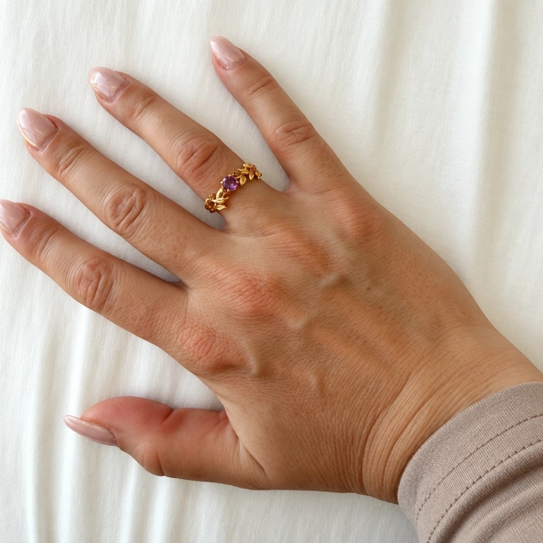 Ametyst ring b�ret p� pegefingeren — 18k guldbelagt bladgren slynger sig rundt med lilla brillantsleben sten i centrum.