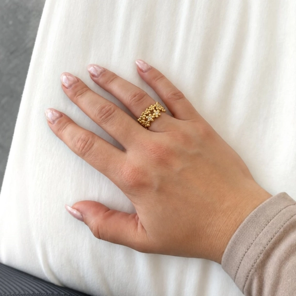 Forglemmigej ring guldbelagt s�lv p� h�nden – varmt gyldent blomsterm�nster med klare topaser, bred og markant.